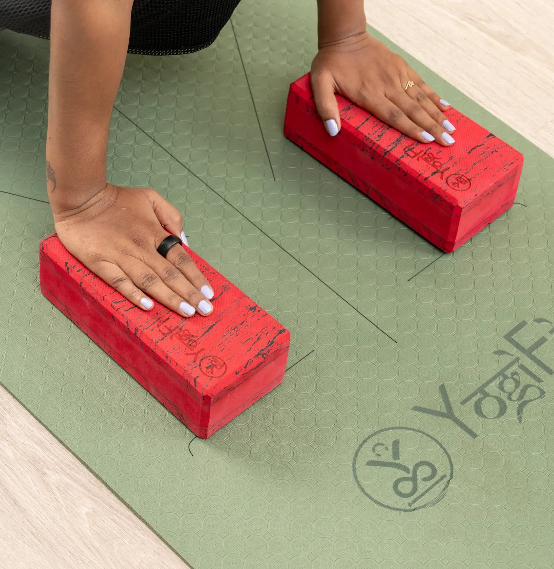 Two yoga blocks placed on a colorful yoga mat in a bright studio.