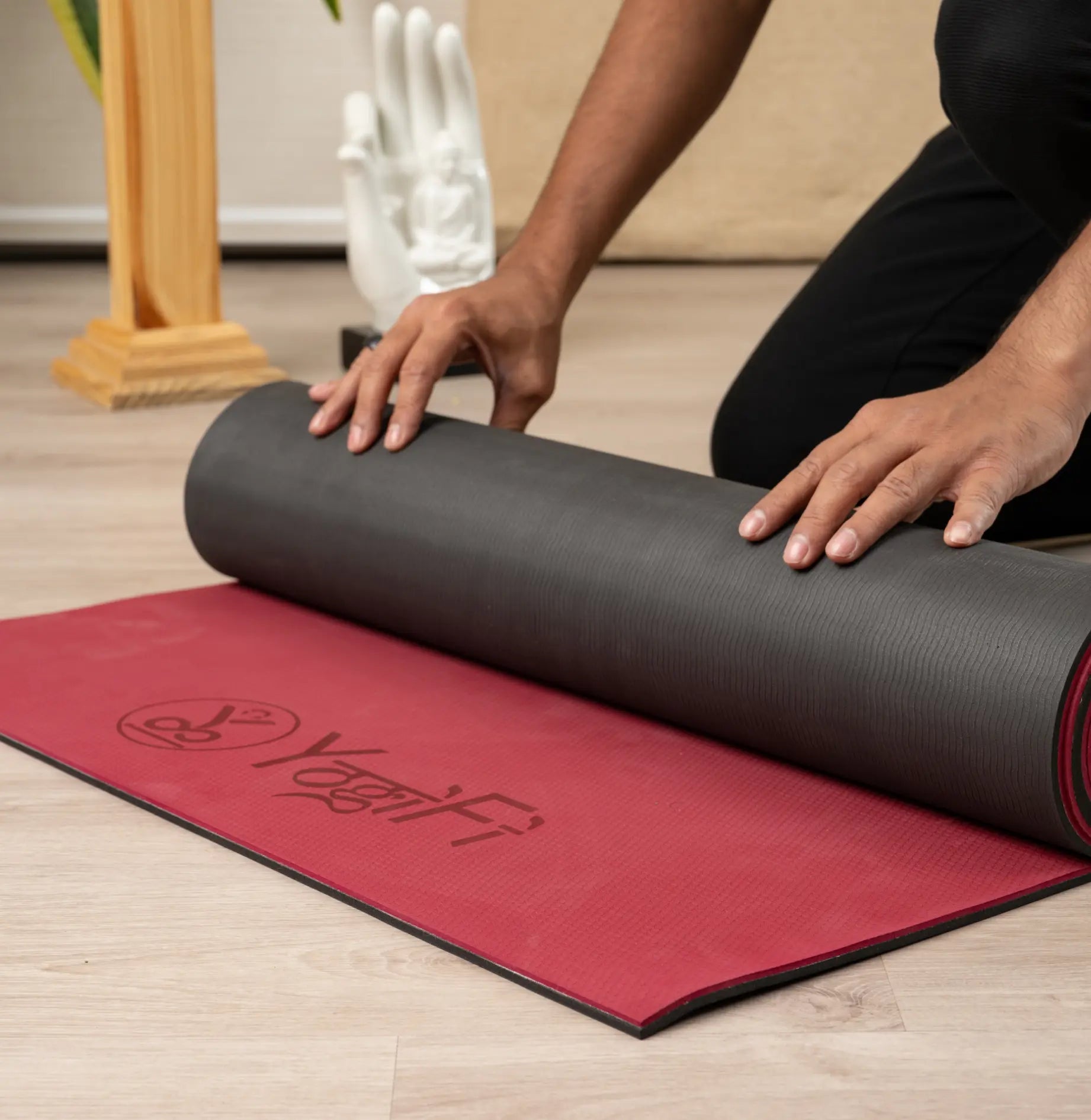 A luxurious wine red yoga mat laid out on a wooden floor, inviting for a calming practice.